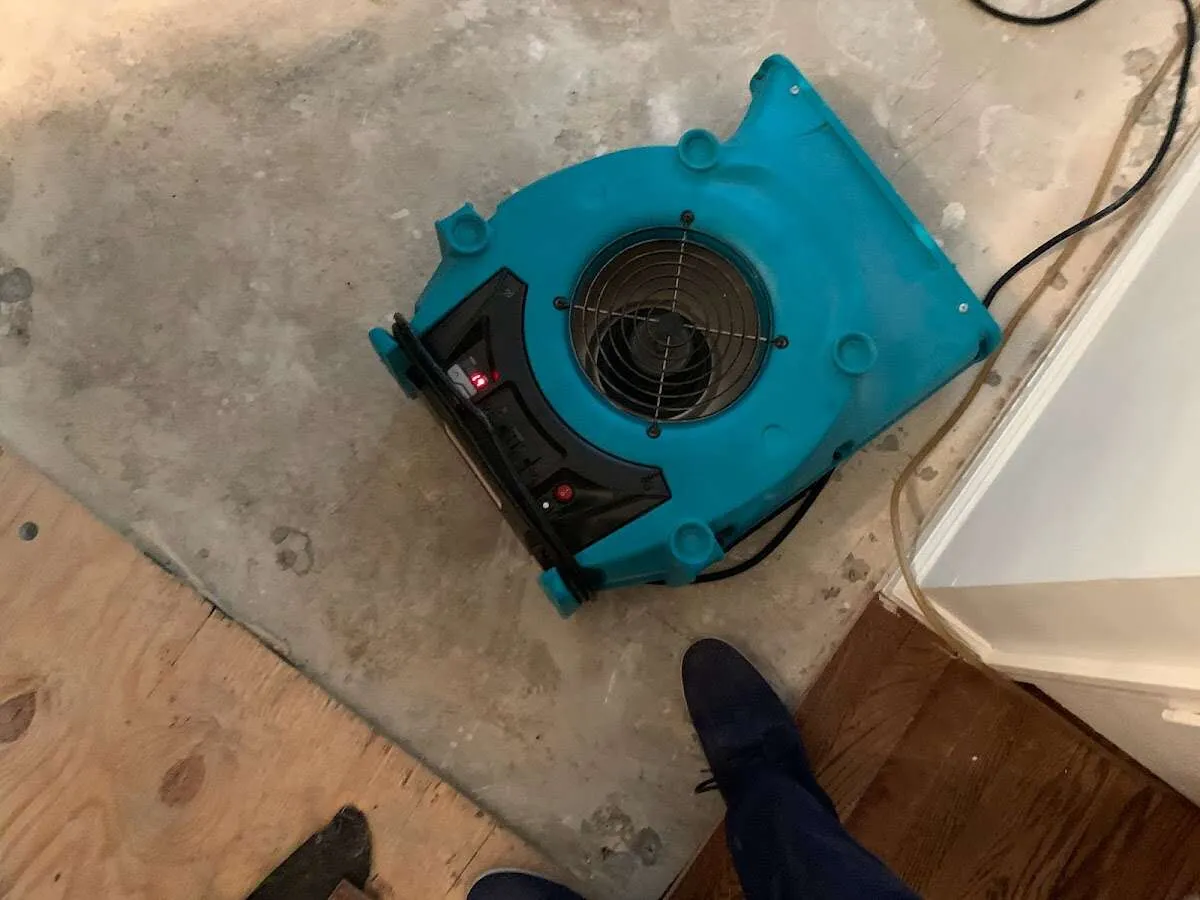 Air mover drying subfloor during Commercial Water Damage Restoration in Johnston
